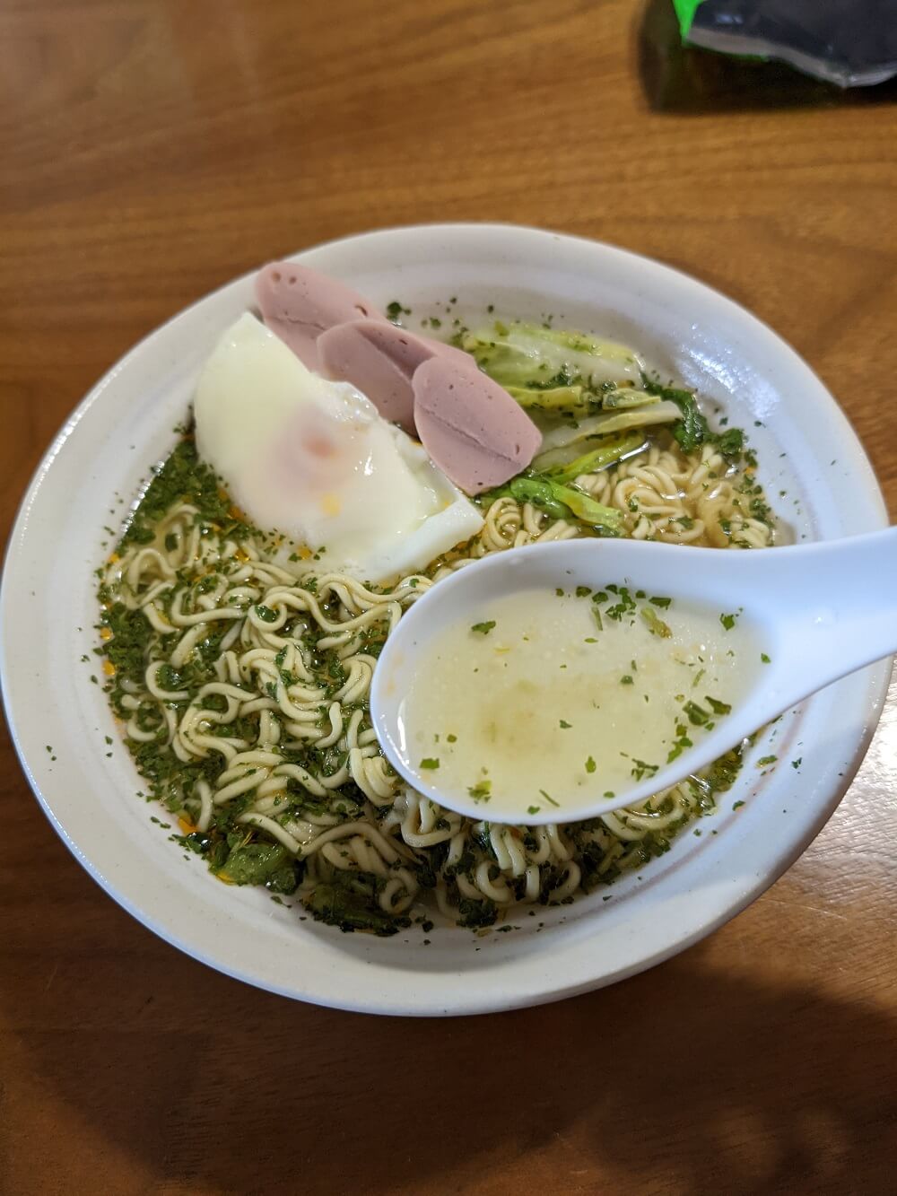 ラーメンのスープをスプーンですくう画像