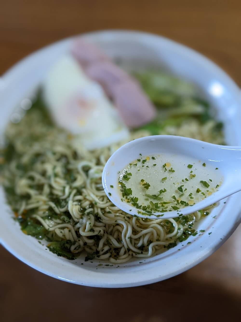 ラーメンのスープをスプーンですくう画像