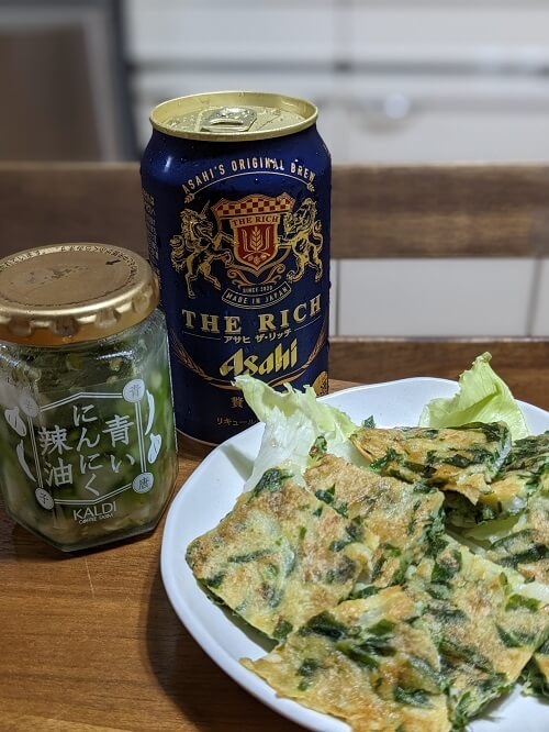 チヂミとビールと調味料の瓶の画像