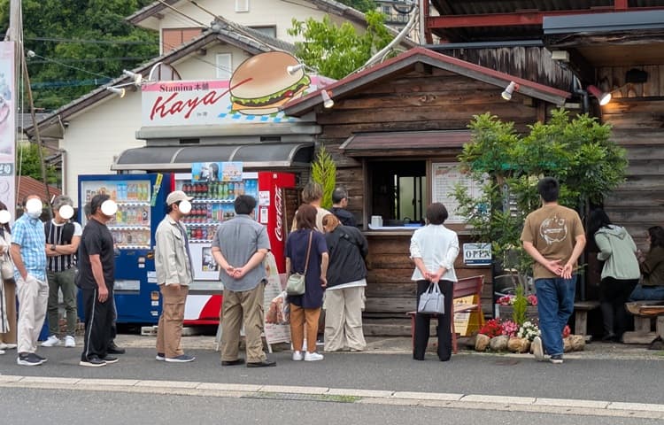ハンバーガー店前で並ぶ人々