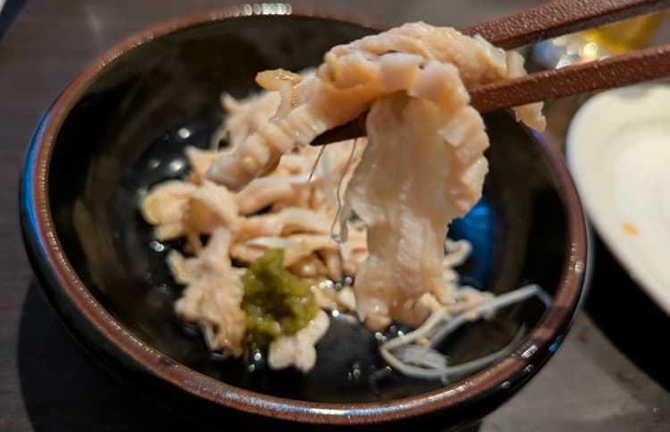 酢もつを箸でつかんでいる画像