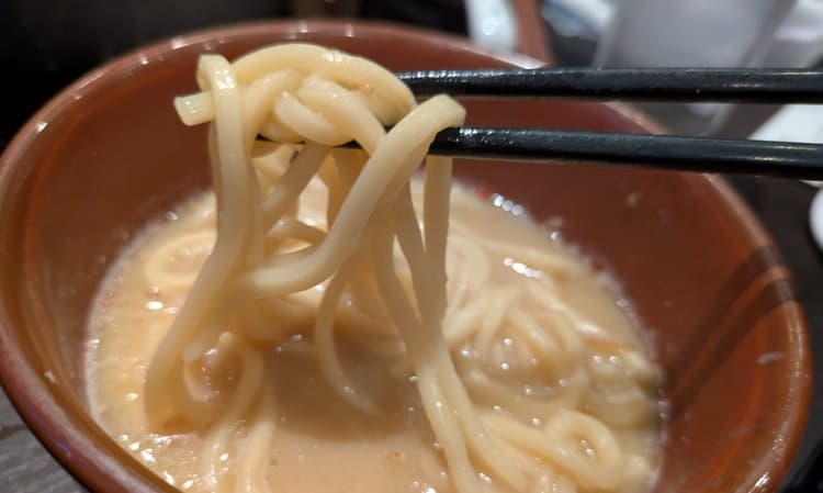 取り皿のうどんをすくう場面