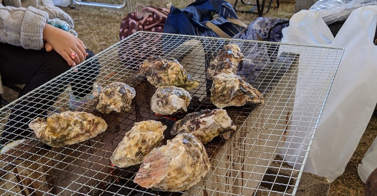 野外で牡蠣を焼く画像